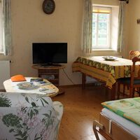 Ferienwohnung "Rivaner": Wohnraum mit Sofaecke, Esstisch und Bett